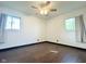Bedroom features hardwood flooring, neutral walls, ceiling fan with lighting and two windows with neutral colored curtains at 503 Elmhurst Pl, Whiteland, IN 46184