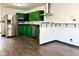 Updated kitchen with stainless steel appliances, granite countertops, green cabinetry, and stylish hardwood floors at 503 Elmhurst Pl, Whiteland, IN 46184
