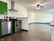 Charming kitchen featuring stainless steel appliances, green cabinets, and hardwood floors flowing into an open layout at 503 Elmhurst Pl, Whiteland, IN 46184