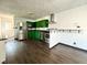 Modern kitchen features stainless steel appliances, green cabinets, granite countertops, and hardwood floors at 503 Elmhurst Pl, Whiteland, IN 46184