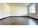 An empty living room featuring neutral walls, wood-look floors, and a window allowing natural light at 503 Elmhurst Pl, Whiteland, IN 46184
