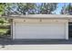 Two car garage with a white door, numbers 55 and 56 above, and room for parking in front at 5038 Allisonville Rd # E, Indianapolis, IN 46205