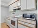 Bright kitchen with white cabinets, an electric stove, and a microwave for convenient cooking at 5038 Allisonville Rd # E, Indianapolis, IN 46205