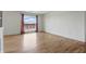 Bright and airy living room featuring hardwood floors, a large window with curtains, and neutral walls at 5038 Allisonville Rd # E, Indianapolis, IN 46205