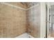 Traditional shower with tile surround, decorative trim, and brushed gold hardware at 5038 Allisonville Rd # E, Indianapolis, IN 46205