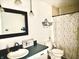 A quaint bathroom featuring a dark vanity with a large framed mirror and a shower with a decorative floral curtain at 5200 N Leslie Dr, Muncie, IN 47304