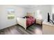 Cozy bedroom featuring wood-look floors, and bright windows, with a wooden bed and dressers at 5200 N Leslie Dr, Muncie, IN 47304