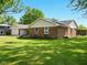 A well-kept single-story home featuring a brick exterior and a lush green lawn at 5200 N Leslie Dr, Muncie, IN 47304