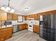 Charming eat-in kitchen with wood cabinets, stainless appliances, light countertops, and gray wood floors at 5200 N Leslie Dr, Muncie, IN 47304