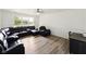 Spacious living room with gray floors, ceiling fan, and large windows provides ample natural light at 5200 N Leslie Dr, Muncie, IN 47304