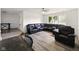 Bright living room showcases a sizable black leather sectional and gray wood-look flooring at 5200 N Leslie Dr, Muncie, IN 47304