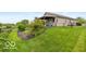 View of the home's backyard with mature landscaping and a well-manicured lawn at 5410 Brassie Dr, Indianapolis, IN 46235