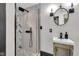 Bathroom features a stone shower, vanity and round mirror at 543 Fletcher Ave, Indianapolis, IN 46203