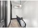 Bright hallway with dark railing, natural light, and stained glass accent in the stairwell at 543 Fletcher Ave, Indianapolis, IN 46203