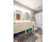Well-lit bathroom featuring a double vanity, matching mirrors, tiled floors, and neutral gray walls at 5522 Grassy Bank Dr, Indianapolis, IN 46237