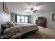 Spacious carpeted bedroom with a ceiling fan and natural light from a bank of windows at 5522 Grassy Bank Dr, Indianapolis, IN 46237