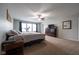 Spacious carpeted bedroom with a ceiling fan and natural light from a bank of windows at 5522 Grassy Bank Dr, Indianapolis, IN 46237