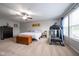 Spacious carpeted bedroom featuring a ceiling fan, dresser, and a treadmill at 5522 Grassy Bank Dr, Indianapolis, IN 46237