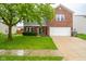 Two-story home with brick and siding, features a two car garage and manicured lawn at 5522 Grassy Bank Dr, Indianapolis, IN 46237