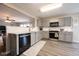 Open-concept kitchen with gray cabinets, modern appliances, and a view into the living area at 5522 Grassy Bank Dr, Indianapolis, IN 46237