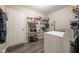 Functional laundry room with shelving for storage, gray floors, and a clean white door at 5522 Grassy Bank Dr, Indianapolis, IN 46237