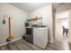 Functional laundry room with shelving for storage, gray floors, and modern appliances at 5522 Grassy Bank Dr, Indianapolis, IN 46237