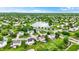 An aerial view captures a serene neighborhood featuring homes surrounding a tranquil pond, framed by lush greenery at 5523 Gainesway Dr, Greenwood, IN 46142