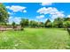 Expansive backyard featuring a large grassy area, wooden deck, and mature trees providing shade and privacy at 5523 Gainesway Dr, Greenwood, IN 46142