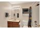 Well-lit bathroom featuring a wood vanity, mirror with decorative lighting, and a shower with a colorful curtain at 5523 Gainesway Dr, Greenwood, IN 46142
