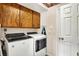 Laundry room features a white washer and dryer set, and wood cabinets for storage at 5523 Gainesway Dr, Greenwood, IN 46142
