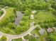 Aerial view of a park with a pond, playground, and a basketball court surrounded by trees and homes at 6039 Chinkapin Dr, Columbus, IN 47201