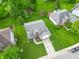 Aerial view of home showcasing its manicured lawn, landscaping, and proximity to lush trees and nearby homes at 6039 Chinkapin Dr, Columbus, IN 47201