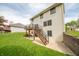 View of home's backyard featuring lush green grass and a wooden deck with stairs leading to a concrete patio at 6039 Chinkapin Dr, Columbus, IN 47201