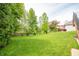 A spacious backyard with a lush green lawn, mature trees, and a wooden deck, offering a serene outdoor space at 6039 Chinkapin Dr, Columbus, IN 47201