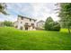A spacious backyard with a lush green lawn, a deck, and mature trees, offering a serene outdoor space at 6039 Chinkapin Dr, Columbus, IN 47201