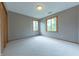 Bright, neutral bedroom with plush carpeting and natural light from the two windows at 6039 Chinkapin Dr, Columbus, IN 47201