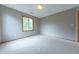 Bright bedroom with large window offering backyard views and a neutral colored carpet at 6039 Chinkapin Dr, Columbus, IN 47201