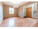 Spacious dining room with wood floors, a modern chandelier, and a staircase leading to the second floor at 6039 Chinkapin Dr, Columbus, IN 47201