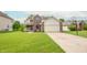 Well-maintained home with a lush green lawn, brick accents, vinyl siding, and a two-car garage at 6039 Chinkapin Dr, Columbus, IN 47201