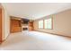 Open living room featuring built-in cabinets, a fireplace, large windows, and neutral colored carpet at 6039 Chinkapin Dr, Columbus, IN 47201