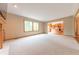 Spacious living area with large windows, neutral carpet, and an open layout leading to the kitchen at 6039 Chinkapin Dr, Columbus, IN 47201
