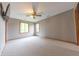 Spacious bedroom with carpet, two windows, a ceiling fan, and a TV mounted on the wall at 6039 Chinkapin Dr, Columbus, IN 47201