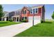 Charming two-story home with red siding, brick accents, long driveway, and attached two car garage at 6212 N Woods Edge Dr, McCordsville, IN 46055