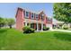 Charming two-story home with red siding, brick accents, manicured lawn, and covered front porch at 6212 N Woods Edge Dr, McCordsville, IN 46055