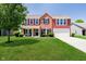 Charming two-story home with red siding, brick accents, manicured lawn, and attached two car garage at 6212 N Woods Edge Dr, McCordsville, IN 46055