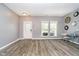 Bright living room with gray walls, wood floors, stylish light fixtures, and large windows at 6212 N Woods Edge Dr, McCordsville, IN 46055