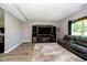 Comfortable living room with cozy furniture, wood floors, entertainment center, and large window at 6212 N Woods Edge Dr, McCordsville, IN 46055