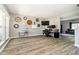 Open-concept living room with gray walls, wood floors, stylish desk, and view of the staircase at 6212 N Woods Edge Dr, McCordsville, IN 46055