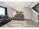Living room view of the modern kitchen, wood floors, gray walls, and staircase at 6212 N Woods Edge Dr, McCordsville, IN 46055