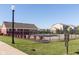 Community pool surrounded by lush landscaping, with a view of nearby residences and a clear blue sky at 6212 N Woods Edge Dr, McCordsville, IN 46055